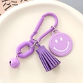 Detail of purple keychain with smile face charm, suede tassel, bell and D-ring buckle - Purple