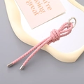 Handmade pink woven leather keychain with silver metal ring on a minimalist white tray - Pink