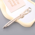 Dettaglio portachiavi in pelle PU intrecciata color crema con anello in metallo - Bianco