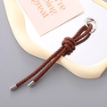 Detail eines braunen geflochtenen Leder-Schlüsselanhängers mit silbernem Karabinerring - Geflochtener Anhänger (K4880) / Kaffeebraun