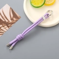 Dettaglio del cordino in nylon intrecciato viola con anello in metallo argento e nodo decorativo - Viola