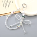 Beaded crystal strawberry phone strap with bow charm and silver metallic clasp - White