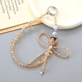 Detail of beaded phone strap with champagne crystal beads and rhinestone strawberry pendant - Champagne