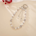 Detail eines Luxus-Perlenanhängers für Taschen mit einem funkelnden Strass-Schleife - Strass Schleife Anhänger / Lila (K5044)