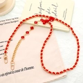 Detalle de cadena dorada con cinta de seda roja y cinco colgantes de rubí cuadrados - Cadena Cruzada (K5085) / Cadena Cruzada con Lazo de Satén y Strass Rojo