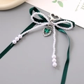 Détail de bijou de sac nœud vert foncé avec perles et pendentif papillon en cœur - Vert Foncé