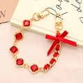Detalle de cristales rojos cuadrados y cinta de seda entrelazada en cadenas doradas - Cadena de Mano (K3360) / Cadena de Mano con Lazo de Satén y Strass Rojo