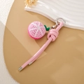 Dettaglio del ciondolo a pesca in maglia rosa fatto a mano con laccetto in pelle PU - Frutto del Drago a Fette (K5138) / Cordino in pelle rosa