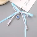Portachiavi con fiocco azzurro, perle bianche e ciondolo a cuore con gemma blu - Blu