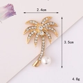 Detailed view of a gold palm tree brooch with sparkling rhinestones and a white pearl accent - Gold Base Pearl Palm Tree