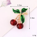 Macro view of cherry accessory with red translucent fruits and green enamel leaves - Gold Base Enamel Red Cherry