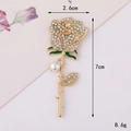 Detail view of rose brooch with white rhinestones, green enamel leaf, and white pearl - Gold Thorny Pearl Rose