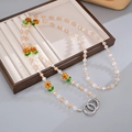 Detailed macro of a beaded crossbody chain with glass flowers and metal spring rings - Khaki