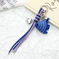 Close-up of handmade crochet fish charm with braided leather strap and heart pendant - Blue Fish Style (K5132)