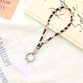 Detailed view of leopard print phone strap with silver ring clip and white connector tab - Wrist Charm (K5093) / Beige Apricot