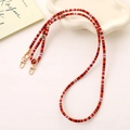 Detail of colorful woven phone strap with golden lobster clasp and striped pattern - Orange