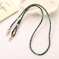Detail of retro ethnic braided phone strap with green and red weave and gold clips - Green