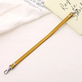 Detail of yellow PU leather bag strap with silver lobster clasps and metal rivets - Cross Pattern Leather Hand Chain / Yellow