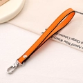 Detail of orange leather wrist strap with silver metal swivel lobster clasp and black edges - Cross Pattern Leather Hanger / Orange