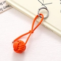 Detail view of handmade orange braided leather ball keychain with silver spring clasp hook - Orange Braided Ball (K5244)