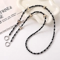 Close-up of beaded crossbody chain featuring butterfly charms and metal spring clasps - Black