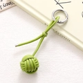 Detailed view of handmade woven leather ball keychain in avocado green with silver ring - Grass Green Braided Ball (K5245)
