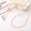 Detail view of pink beaded phone strap with gold butterfly charms and silver ring clasps - Pink