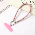 Detailed close-up of pink PU leather wrist strap with silver metal ring and phone connector - Pink
