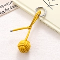 Detailed macro of yellow woven PU leather ball pendant with polished silver metal ring - Yellow Braided Ball (K5253)