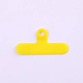Détail d'un onglet de fixation jaune vif en PVC pour lanière de téléphone avec oeillet - Clip / Jaune