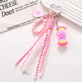Detail of pink hand-woven candy phone charm with lace ribbon and heart metal clasp - Charm / Rose Red