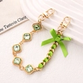Golden chain accessory with green crystals, silk ribbon weave, and bow detail - Hand Chain (K5371) / Rhinestone Ribbon Bow Hand Chain Grass Green