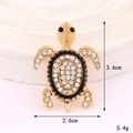 Vista macro di ciondolo a tartaruga dorata con strass, misura 3,6cm x 2,6cm e pesa 5,4g - Base Oro Tartaruga Ovale Nero (D3296)