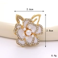 Dettaglio macro della spilla fiore smaltato con perla e strass, misura 2,6 cm per 2,8 cm - Camelia in Smalto (Base Dorata Bianco)