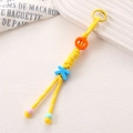 Close-up of handmade yellow braided rope keychain with colorful OK letter beads - Yellow