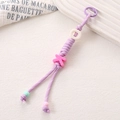 Detailed macro shot of purple nylon braided rope keychain with a pink letter K charm - Purple