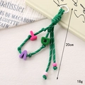 Detail of green woven nylon phone charm with colorful letter beads on a bright background - Charm / Dark Green