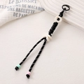 Détail du pendentif tissé main avec perles de lettres et petites perles de finition - Noir
