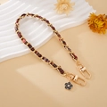 Close-up of gold metal chain with tweed ribbon and camellia flower pendant detail - Hand Chain / Coffee