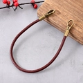 Retro-Handgelenkschlaufe aus braunem Leder mit doppelten Bronzeschließen auf grauem Grund - Taschengriff-Kette / Retro Rindsleder Tragekette Dunkelkaffee (K5431)