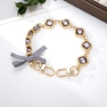Golden chain strap with lavender gemstones, grey ribbon bow, and lobster clasps - Rhinestone Ribbon Bow Hand Chain Gray