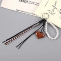 Dettaglio del ciondolo a cuore in resina marrone con perle e cordini in pelle nera - Ciondolo a Cuore in Corda Intrecciata di Pelle (K5557) / Marrone Scuro