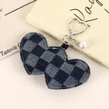 Detail of a blue denim checkerboard heart charm with a silver heart clasp and pearl bead - Navy Plaid