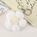 Détail du porte-clés fleur en peluche avec pétales blancs et fermoir en métal argenté - Blanc