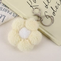 Detail of plush flower charm with yellow petals, white center, and silver metal clasp - Yellow