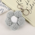 Close-up of soft grey plush flower keychain with silver metal clasp on warm aesthetic background - Light Green