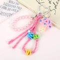 Detail eines handgefertigten rosa Perlenpilz-Anhängers mit Buchstabenband - Rosa