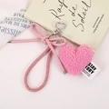 Close-up of pink plush heart keychain with a leather bow and shiny metal clasp - Pink