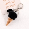 Detailed close-up of ice cream charm with black faux fur ball and leather tassel - Black