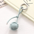 Close-up of light blue hand-woven PU leather ball keychain with silver spring buckle - Light Blue Braided Ball (K5254)